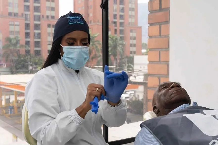 Odontóloga preparándose para atender a un paciente en el consultorio de RI Dental
