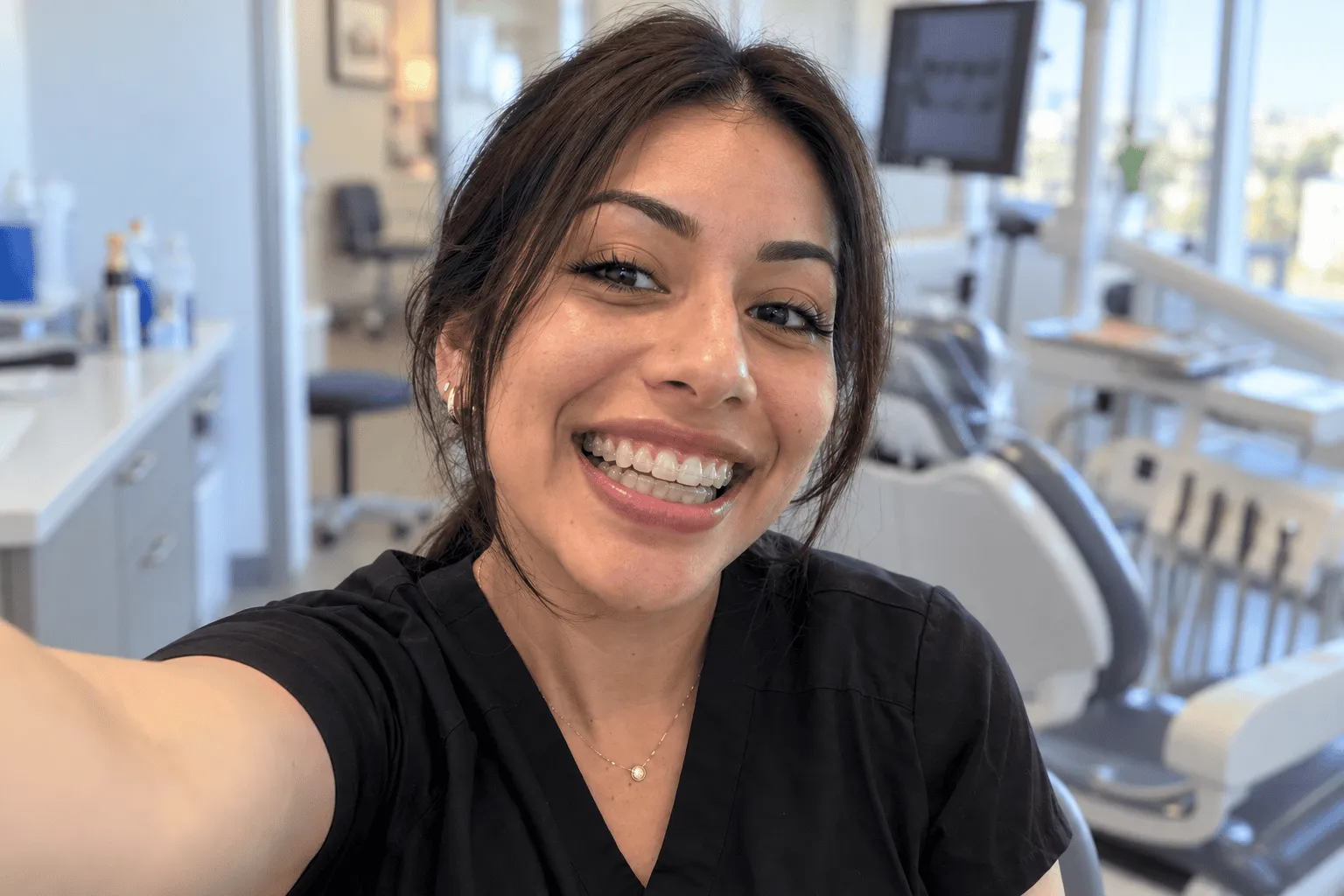 Paciente sonriendo con brackets transparentes en el consultorio